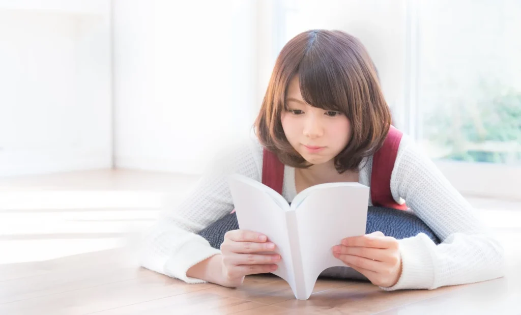 うつ伏せで本を読む女性